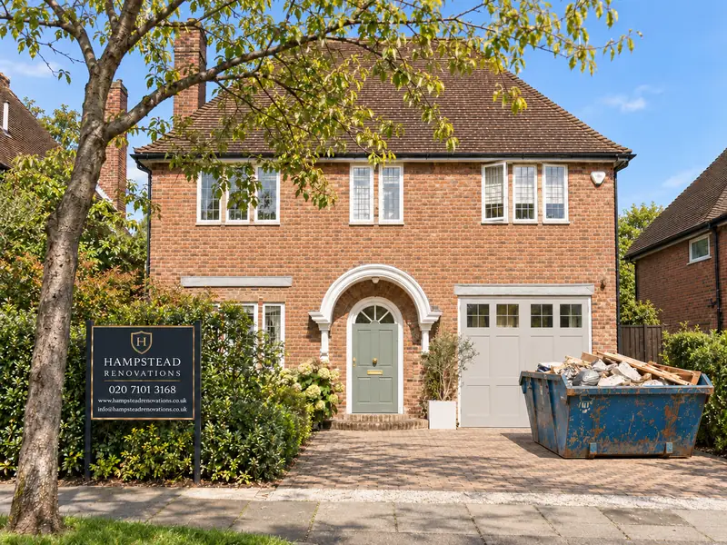 Meadway, Hampstead Garden Suburb: brick house with a Hampstead Renovations site board and a skip on the drive